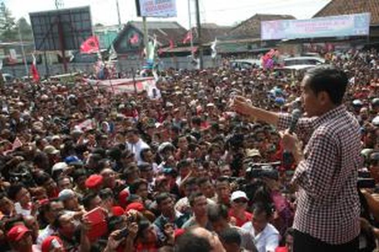 Capres, Joko Widodo (Jokowi) memberikan salam dua jari saat tiba di Pasar Sokaraja, Banyumas, Jawa Tengah, Jumat (13/6/2014). Ribuan warga memenuhi halaman pasar untuk mendengarkan orasinya. Dalam kesempatan itu, ia menegaskan ingin menasionalkan program Kartu Indonesia Sehat dan Kartu Indonesia Pintar jika ia terpilih sebagai presiden.