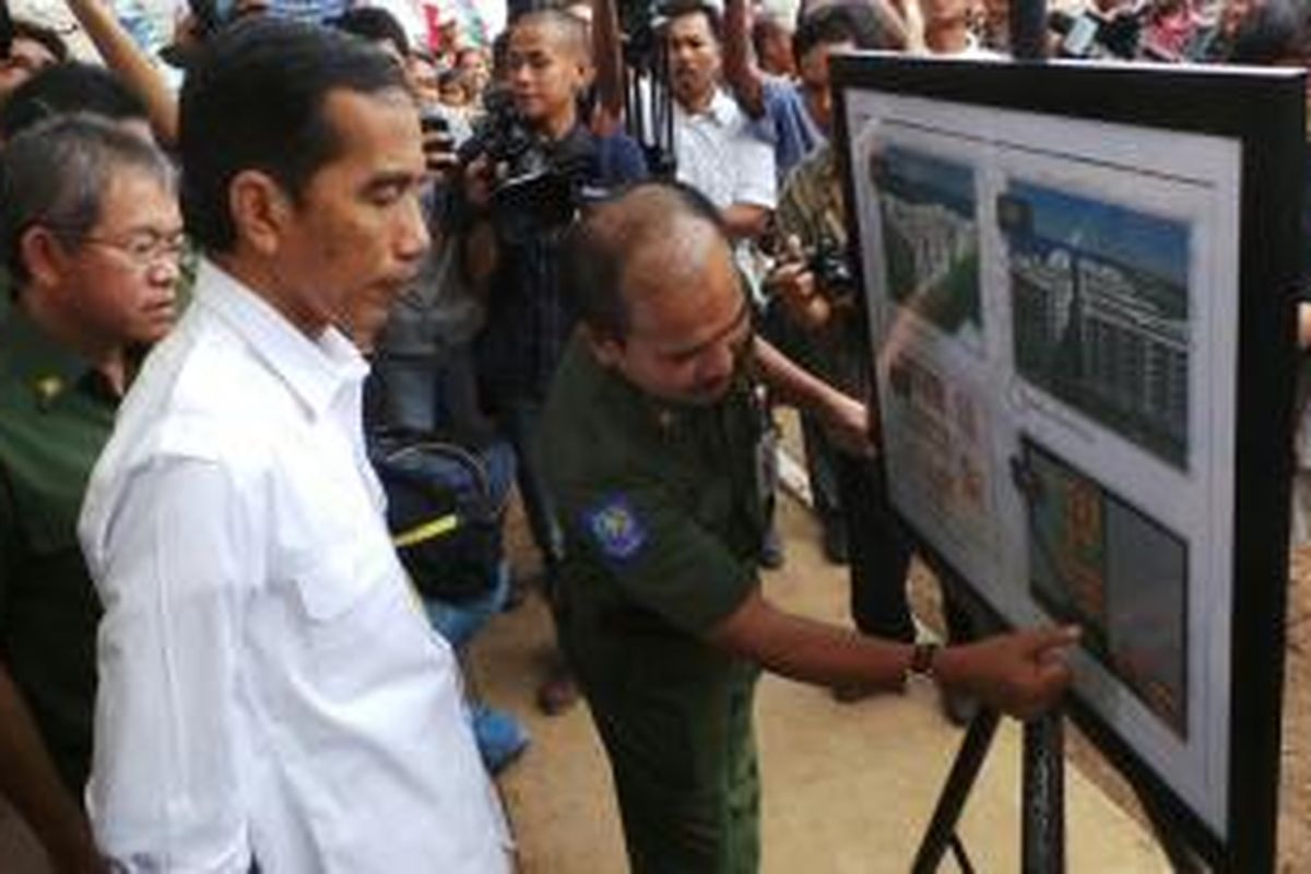 Gubernur DKI Jakarta Joko Widodo mendengarkan penjelasan mengenai pembangunan rumah susun sederhana sewa di Muara Baru, Jakarta Utara, Senin (15/7/2013). Hari ini Jokowi melakukan peletakan batu pertama sebagai tanda pembangunan rusunawa tersebut.