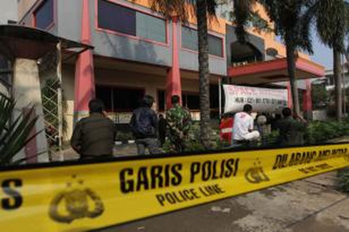 Garis polisi terpasang di tempat terjadinya ledakan di Gedung Multi Piranti Graha, Duren Sawit, Jakarta Timur, Senin (16/11/2015). Ledakan yang menghancurkan kaca depan gedung dan melukai seorang penjaga keamanan ini diduga berasal dari granat tangan.