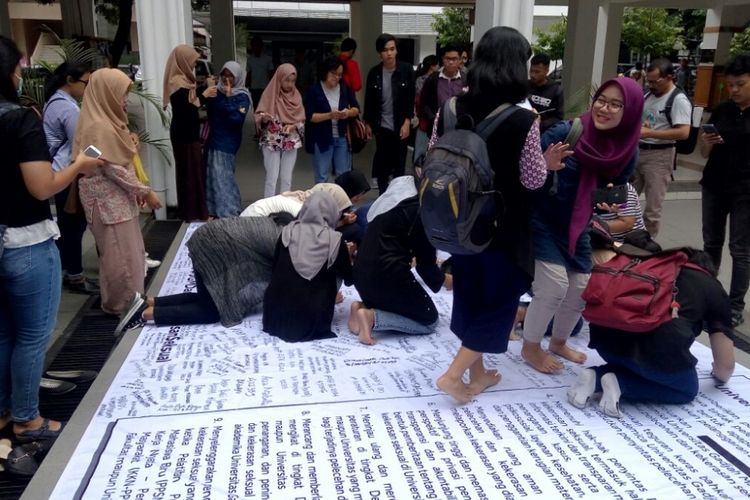 Para mahasiswa saat membubuhkan tanda tangan di sebuah Baliho dalam aksi di Taman San Siro Fisipol UGM.