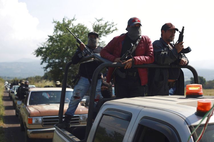 Anggota kelompok yang disebut kelompok bela diri yang dikenal sebagai United Towns atau Pueblos Unidos, berkumpul untuk rapat umum di Nuevo Urecho, di negara bagian Michoacan, Meksiko barat, Sabtu 27 November 2021. 