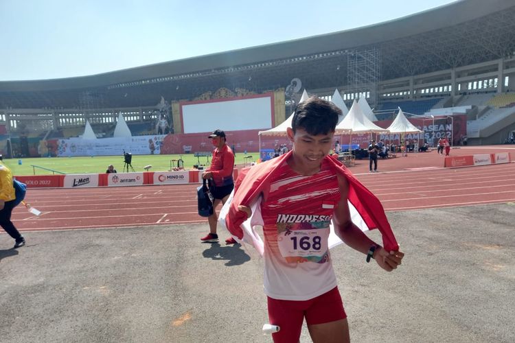 Atlet para-atletik Indonesia Sapto Yogo Purnomo membawa bendera Merah Putih usai meraih medali emas nomor lari 100 meter T37 putra di Stadion Manahan,  Solo, Senin (1/8/2022) siang WIB.