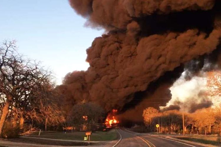 Asap mengepul dari api setelah ledakan yang disebabkan oleh kecelakaan antara kereta api dan kendaraan roda 18 dekat Cameron, Texas, pada Selasa (23/2/2021). 
