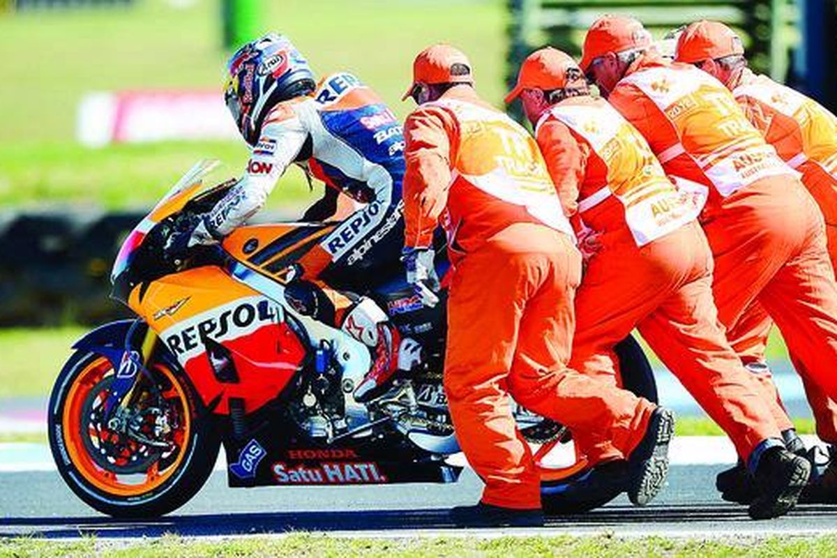Pebalap Honda, Dani Pedrosa (Spanyol), mendapat bantuan petugas setelah terjatuh dari sepeda motornya  pada MotoGP seri Australia di Phillip Island, Minggu (28/10).