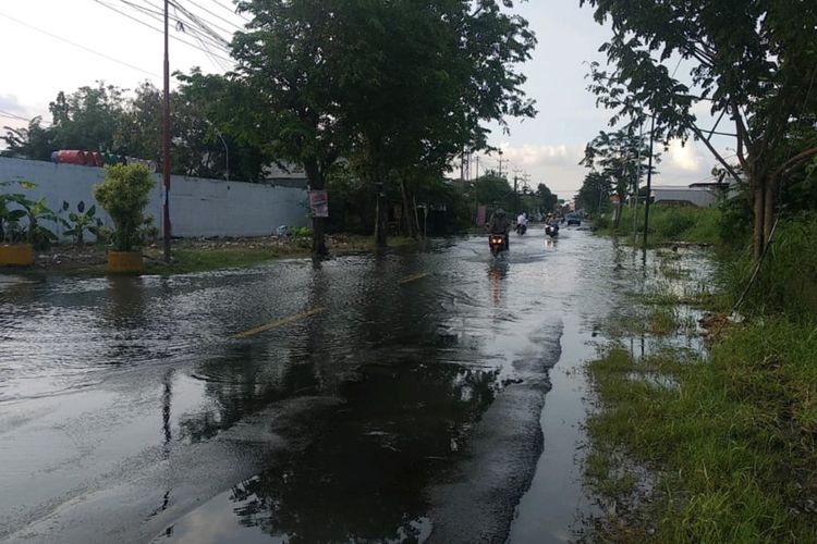 Jalan Raya Boboh di Kecamatan Menganti, Gresik, mulai tergenang air luapan Kali Lamong.