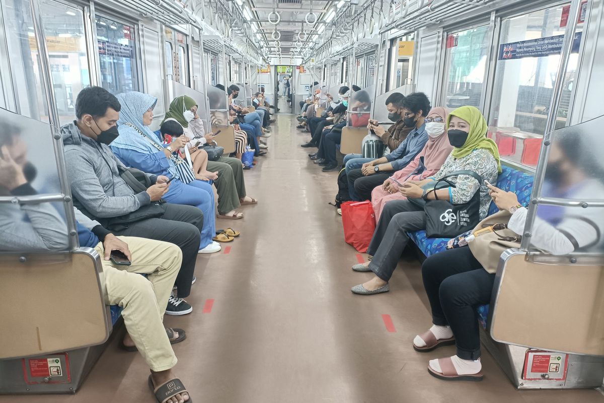 Para penumpang kereta api listrik (commuter line) di Stasiun Bekasi yang kini dapat duduk tanpa berjarak setelah marka jaga jarak dicopot dari tempat duduk penumpang mulai Rabu (9/3/2022). Pencopotan dan pembersihan marka jaga jarak di kereta api ini sendiri tertuang dalam Surat Edaran Kementerian Perhubungan Nomor 25 Tahun 2022. (KOMPAS.com/Joy Andre T)