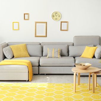 Ilustrasi ruang keluarga dengan perpaduan kuning dan abu-abu.
