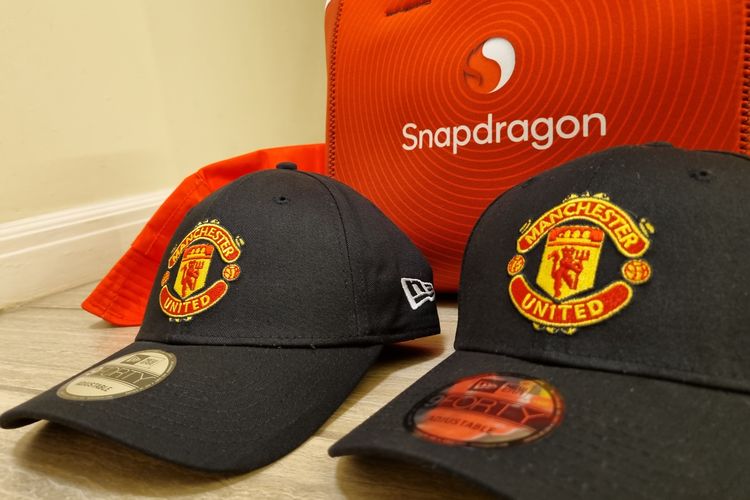 Qualcomm membagikan topi gratis Manchester United sebagai simbol kerja sama.