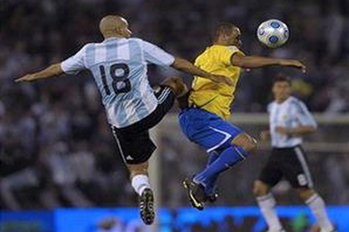 Penyerang Brasil, Luis Fabiano (tengah) sedang berebut bola dengan gelandang Argentina, Juan Sebastian Veron dalam lanjutan kualifikasi Piala Dunia, di Rosario, Senin (6/9).