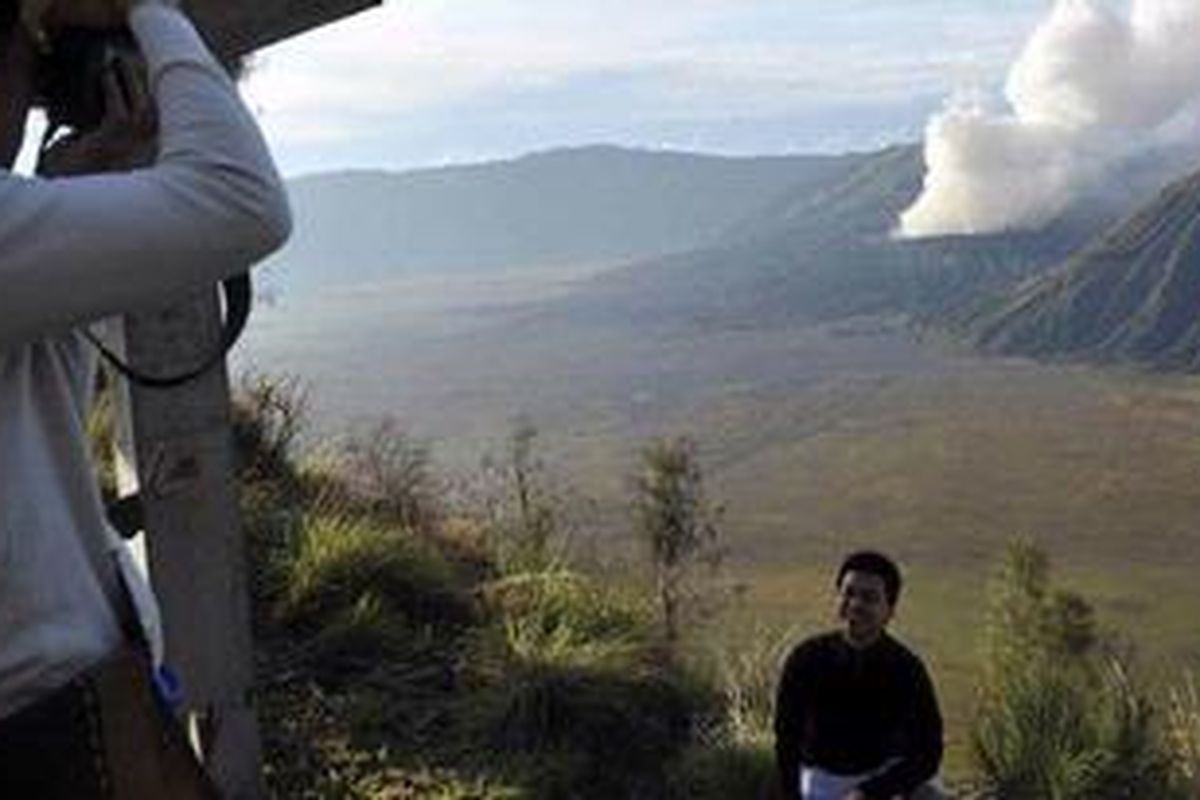 Seorang wisatawan berpose dengan latar belakang Gunung Bromo. Sejak Selasa petang (23/11/2010) status Gunung Bromo dinaikkan menjadi Awas.