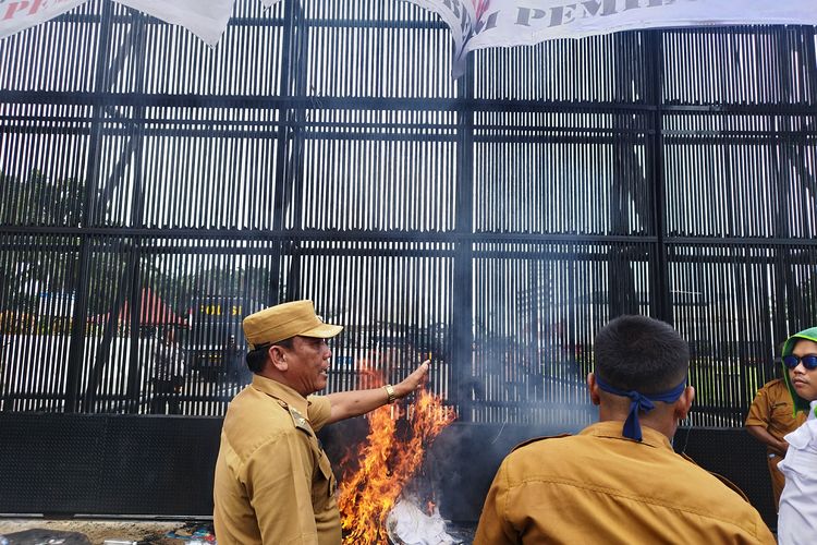 Massa membakar sampah di depan gedung DPR, Jakarta Pusat, Rabu (30/1/2024).