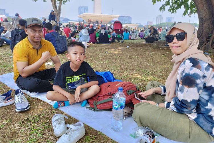 Roji (40) dan keluarganya, datang dari Tangerang untuk menonton HUT TNI yang ke-78 di Monas, Gambir, Jakarta Pusat, Kamis (5/10/2023). (KOMPAS.com/XENA OLIVIA)