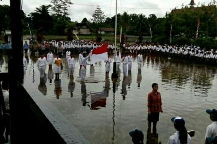 Suasana upacara bendera peringatan HUT ke 72 RI di tengah kondisi banjir di halaman Kantor Camat Bika, Kabupaten Kapuas Hulu, Kalimantan Barat (17/8/2017)