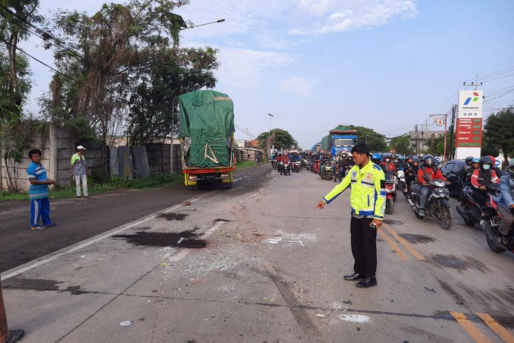 Polisi menunjukkan tempat tabrakan antartruk hingga salah seorang sopir tewas di Jalan Raya Desa Tebaloan, Kecamatan Duduksampeyan, Gresik, Jawa Timur, Senin (11/12/2023).