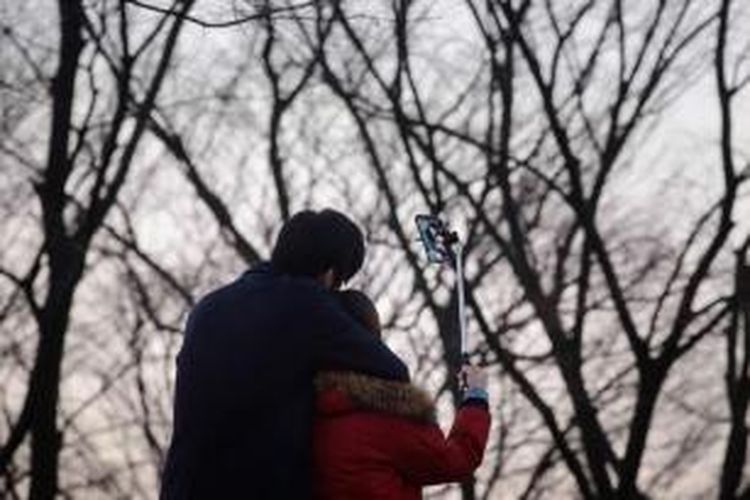 Wisatawan berfoto menggunakan tongkat narsis (tongsis) di salah satu kawasan wisata, di Seoul, Korea Selatan, 26 November 2014. Tongsis yang dijual dan beredar di negara K-pop tersebut diwajibkan melalui sertifikasi khusus.