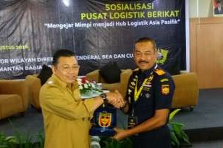 Gubernur Kalimantan Barat, Cornelis (Kiri) menerima penyerahan cenderamata dari Kepala Kanwil Ditjen Bea Cukai Kalimantan Bagian Barat dalam kegiatan sosialisasi Pusat Logistik Berikat di Pontianak (10/8/2016)