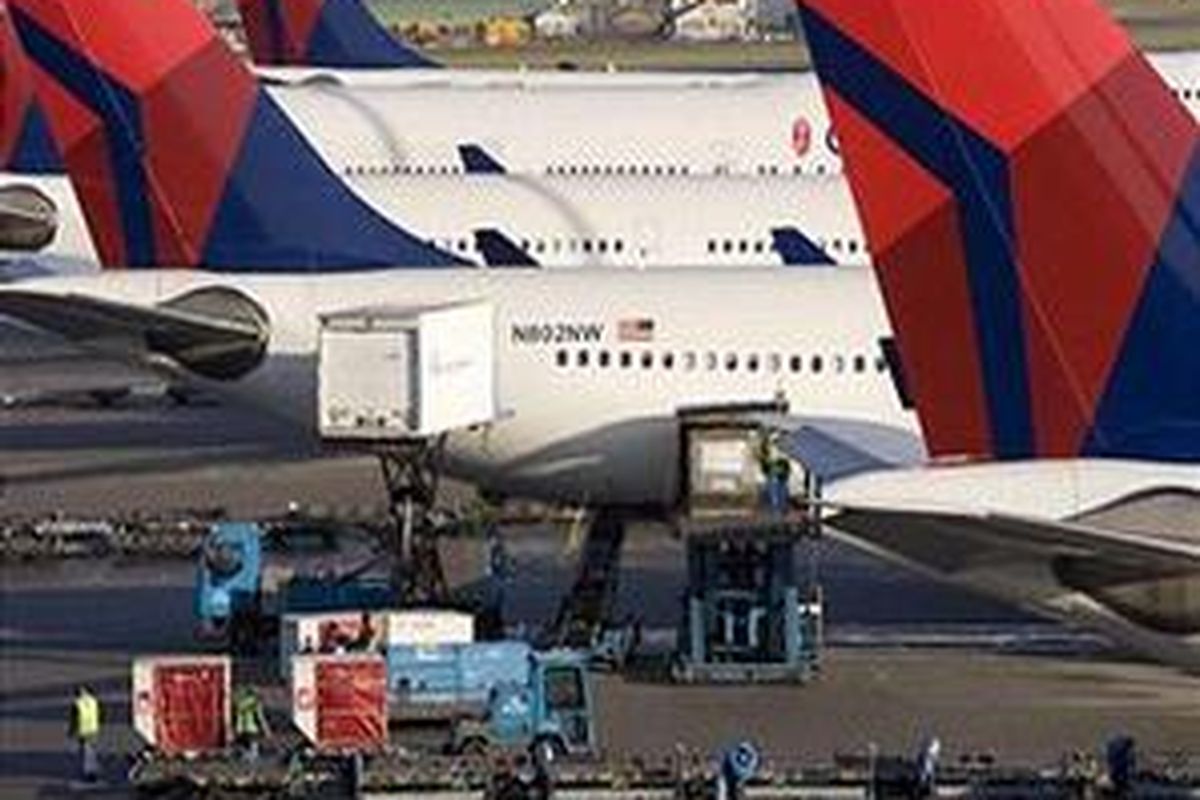 Pesawat Delta-Northwest sedang memuat barang-barang di Bandara Schiphol, Belanda, dengan pengawasan ketat.