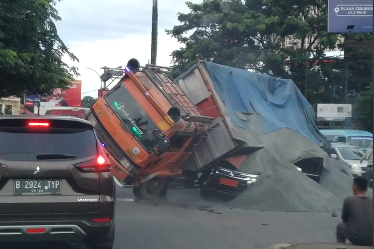 Tangkapan layar foto truk pasir menimpa mobil Pajero hitam di Cibubur, Depok, Jumat (23/12/2022).