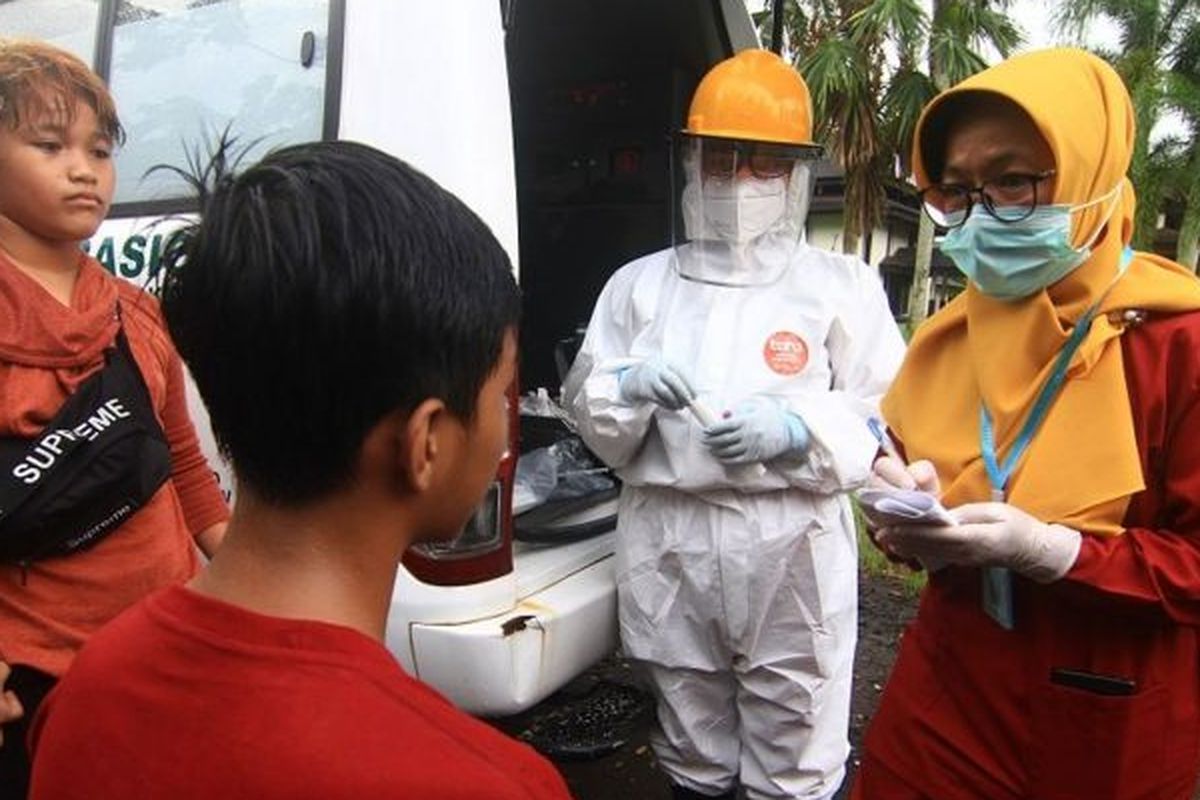 Dua petugas medis mencatat data remaja pesepeda yang terjaring razia kepatuhan penggunaan masker di Jalan Ahmad Yani, Pontianak, Kalimantan Barat, Senin (06/07).