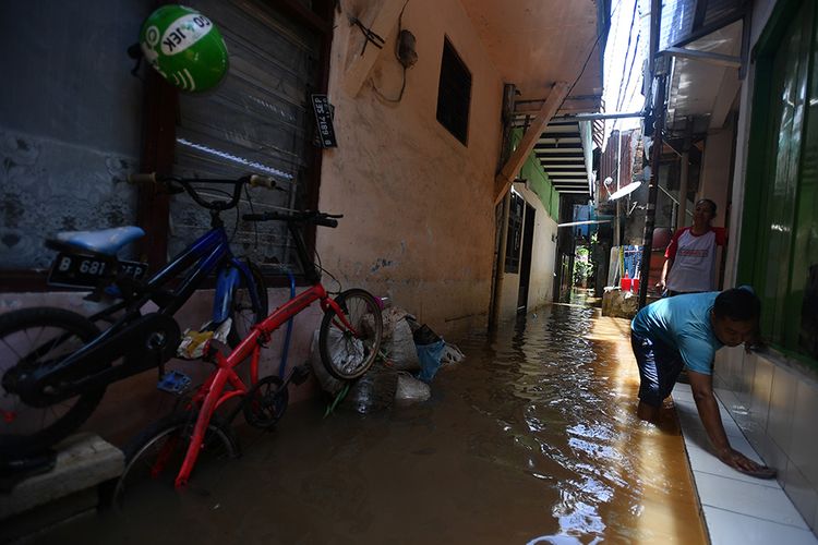 Warga membersihkan lantai saat banjir melanda kawasan permukiman di Petogogan, Kebayoran Baru, Jakarta Selatan, Senin (5/10/2020). Banjir tersebut terjadi akibat meluapnya Kali Krukut.