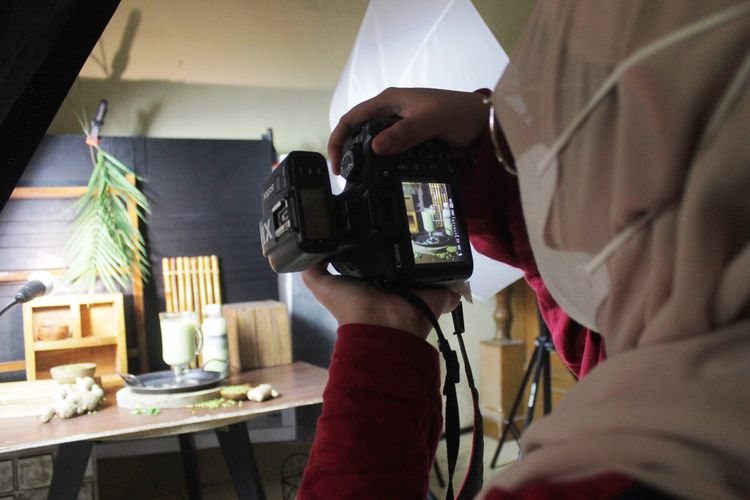 Ani Yuliani (31), seorang ibu di Kabupaten Cianjur, Jawa Barat, sedang memotret produk minuman yang ditata di atas meja.