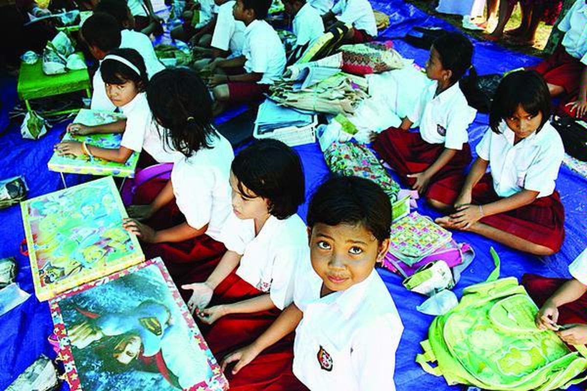 Siswa kelas IV SD Negeri 11 di Desa Parit Malintang, Kecamatan VI Lingkung, Kabupaten Padang Pariaman, Sumatera Barat, yang masih belajar di dalam tenda, Senin (26/10). Di sela-sela jam pelajaran, mereka diajak gurunya menyimak gambar-gambar kartun sebagai upaya penyembuhan trauma.