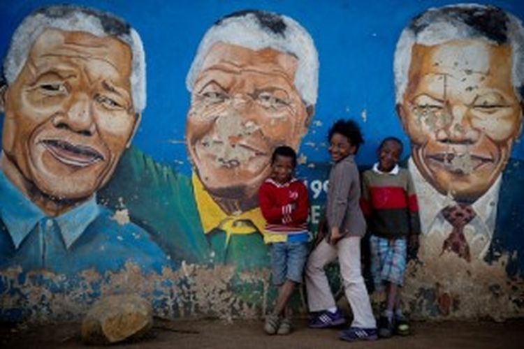 Anak-anak Afrika Selatan berpose di depan mural Nelson Mandela di kota Soweto, menunjukkan kecintaan rakyat yang sangat besar terhadap salah seorang pejuang besar negeri itu.