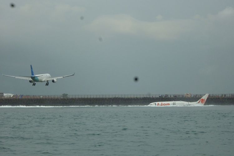 Pesawat Lion Air dengan nomor penerbangan JT-904 rute Bandung-Denpasar masih terendam sebagian dan terbelah dua karena jatuh tidak jauh dari ujung barat landasan
pacu Bandara Internasional Ngurah Rai, Badung, Bali, Sabtu (13/4) sekitar pukul 15.10 Wita.