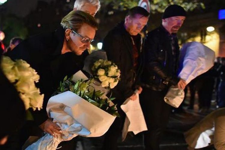 Vokalis band U2, Bono, meletakkan karangan bunga di Bataclan Theatre, Paris, Perancis, Sabtu (14/11/2015). Bono menyatakan turut berduka atas serangan teroris yang menewaskan 153 korban jiwa dan ratusan korban luka lainnya pada Jumat (13/11/2015).