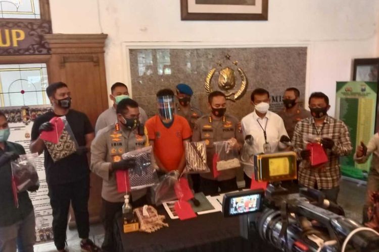 Kapolrestabes Surabaya Kombes Jhoni Isir bersama pelaku dugaan pelecehan seksual fetish kain jarik berinisial G (tengah) di Mapolrestabes Surabaya.