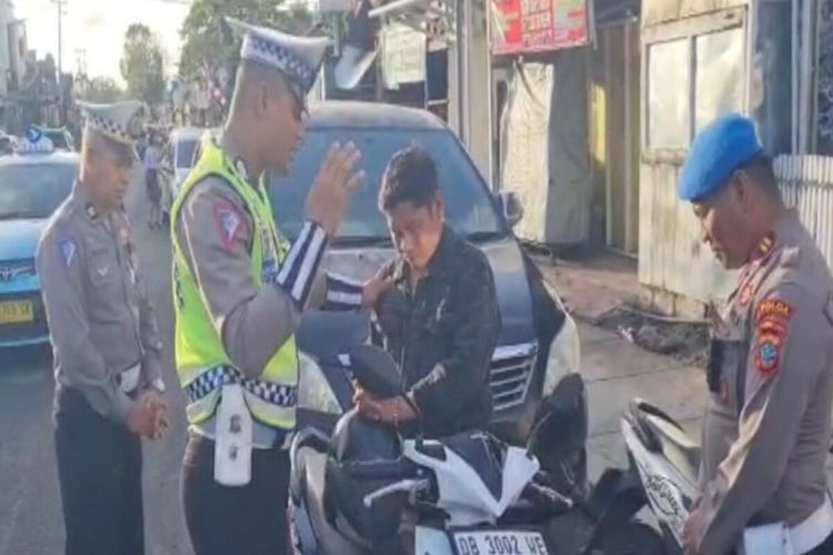 Tangkapan layar pengendara motor terjaring operasi dan didoakan oleh polisi. Video ini terjadi di Kota Manado, Sulawesi Utara, saat petugas kepolisian melakukan operasi.