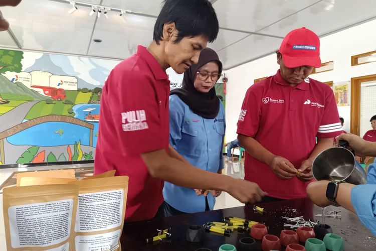 Deni dan Eko sedang membuat lilin aromaterapi dibantu tim Lentera Jiwa. Mereka merupakan ODGJ, warga Pangauban, Bandung Barat, yang sudah pulih.