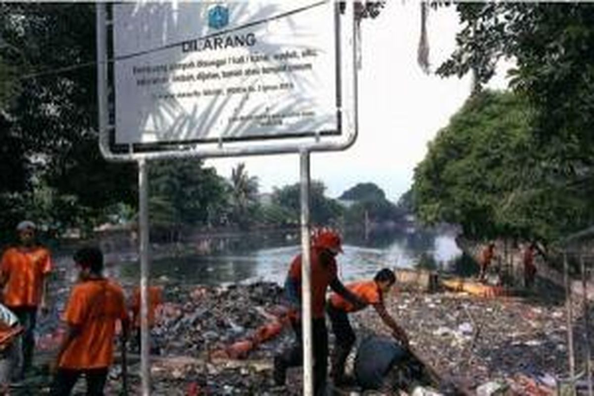 Masyarakat dan petugas membersihkan sampah di Waduk Telok Gong, Jakarta Utara, Minggu (15/2/2015). 
