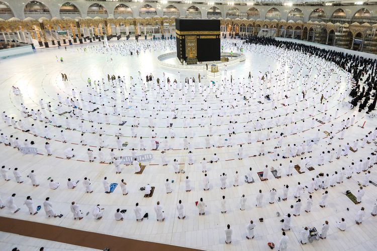 Jamaah Muslim berdoa di sekitar Ka'bah di kompleks Masjidil Haram, tempat suci umat Islam, di kota suci Mekah di Arab Saudi pada 1 November 2020, ketika pihak berwenang memperluas ziarah umrah sepanjang tahun untuk menampung lebih banyak jemaah sambil melonggarkan pembatasan pandemi coronavirus COVID-19 . - Pihak berwenang Saudi sebelumnya telah mengumumkan bahwa tahap ketiga dari perluasan doa mulai dari 1 November akan mengizinkan pengunjung dari luar negeri. Batas jemaah umrah kemudian akan dinaikkan menjadi 20.000, dengan total 60.000 jemaah diperbolehkan. 
