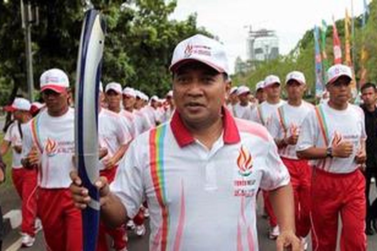 Mantan atlet bulutangkis, Icuk Sugiarto, membawa obor SEA Games 26 menuju kantor Wakil Presiden, Jakarta Pusat, Jumat (4/11/2011). Selanjutnya obor SEA Games akan diarak ke lima wilayah DKI Jakarta, kemudian akan dibawa menuju ke Palembang.