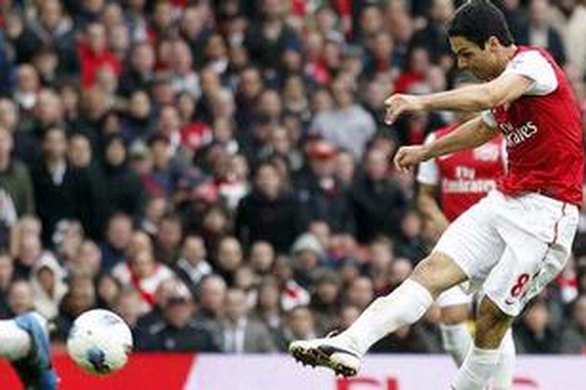Gelandang Arsenal, Mikel Arteta, melepaskan tembakan yang berujung gol ke gawang Manchester City, pada pertandingan Premier League, di Emirates, Minggu (8/4/2012). 