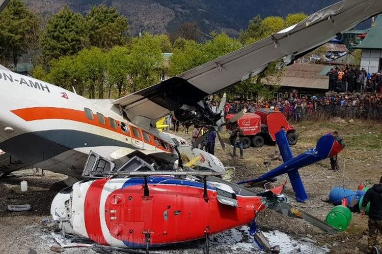 Pesawat Turbolet menabrak dua helikopter saat lepas landas di bandara Lukla, pintu gerbang utama ke wilayah Everest, Minggu (14/4/2019). (AFP/ANG TASHI SHERPA)