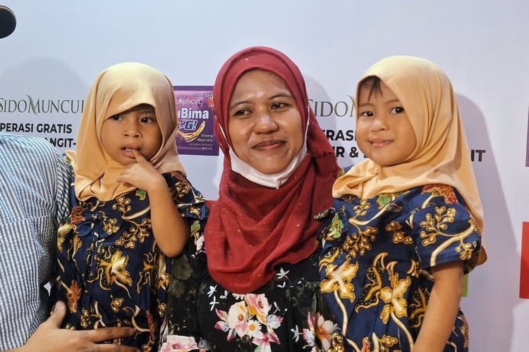 Aini menggendong putri kembarnya, Afifah dan Aliyah, yang mendapatkan bantuan operasi sumbing bibir gratis dari Sido Muncul. Bagi keluarga ini, bantuan tersebut merupakan titik balik untuk kembali merajut harapan di tengah keterbatasan ekonomi.