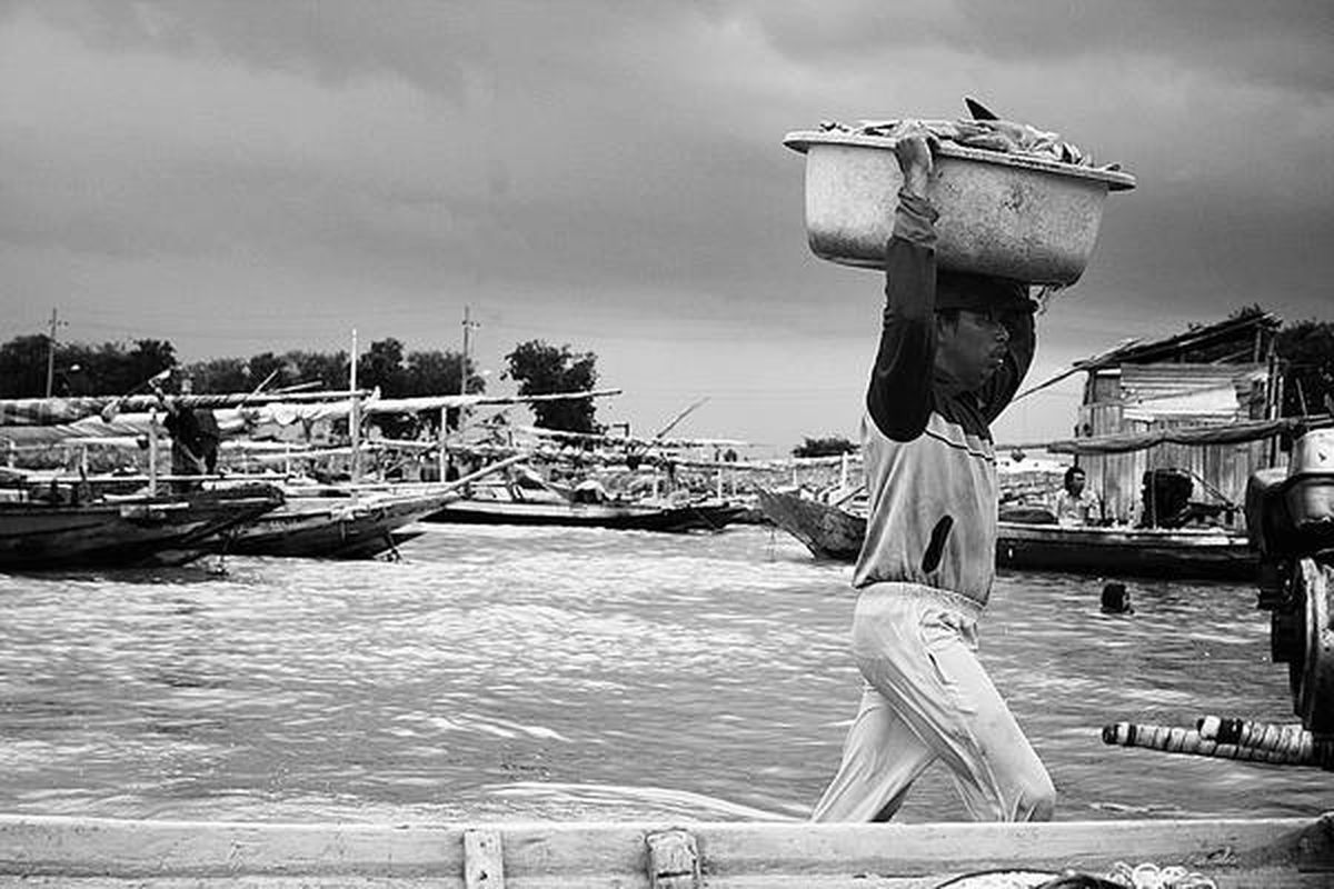 Nelayan membawa hasil tangkapannya untuk dibawa ke Pasar Ikan Kenjeran, Surabaya, Jawa Timur, Minggu (24/2). Dua hari ini para nelayan sudah mulai melaut setelah sepuluh hari sebelumnya tidak melaut karena ombak besar dan angin kencang.  