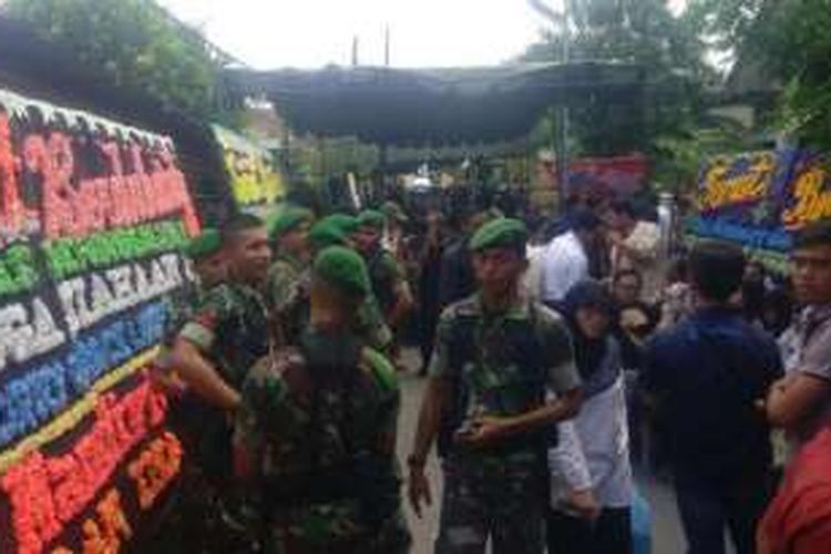 Anggota TNI berseragam lengkap saat berjaga di rumah duka petugas pajak yang tewas ditikam pengusaha karet. 
