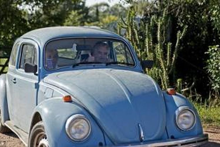 Presiden Uruguay Jose Mujica tengah mengendari mobil VW Beetle kesayangannya.