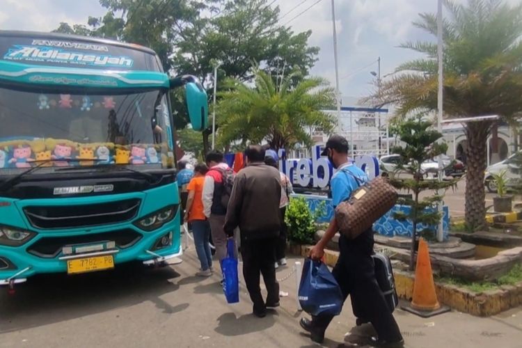 Sejumlah penumpang kereta api naik bus dari Stasiun Cirebon menuju Stasiun Purwokerto, Senin (4/12/2023). Solusi PT KAI Daop 3 Cirebon ini dilakukan karena kereta api yang menuju Purwokerto tidak dapat melintas akibat tertutup material longsor.