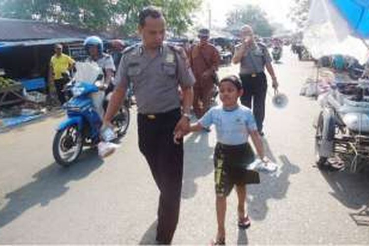 Polisi dengan membawa seorang anak keliling pasar Kota Langsa, Aceh, mengumumkan anak hilang, Senin (7/3/2016)