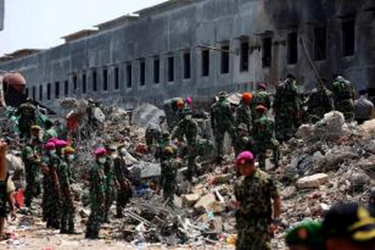 Anggota TNI membersihkan puing pesawat Hercules c-130 TNI AU yang jatuh di Jalan Jamin Ginting, Medan, Sumatera Utara, 1 Juli 2015. Pesawat itu jatuh dua menit setelah lepas landas dari Pangkalan Udara Soewondo pada pukul 12.08 ketika hendak menuju Tanjung Pinang.