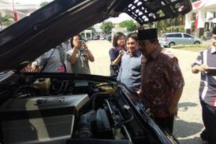 Soekarwo memeriksa mesin mobil dinasnya.