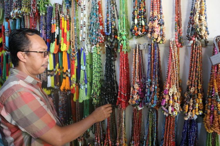 Suloso, salah satu perajin manik-manik, menunjukkan perhiasan yang dijual olehnya di kios Griya Manik, Desa Plumbon Gambang, Kecamatan Gudo, Kabupaten Jombang, Jawa Timur.