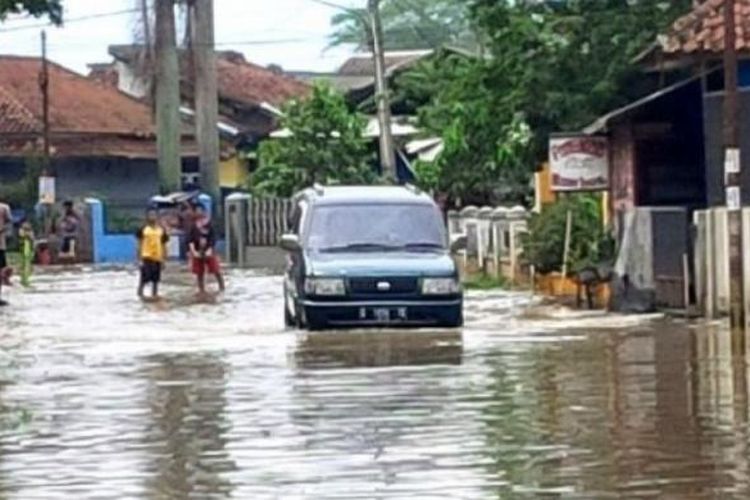 Sebuah mobil mencoba menerobos banjir di kawasan Sapan, Kampung Cikeruh, Desa Tegalluar?, Kecamatan Bojongsoang, Kabupaten Bandung, Rabu (8/3/2017). 