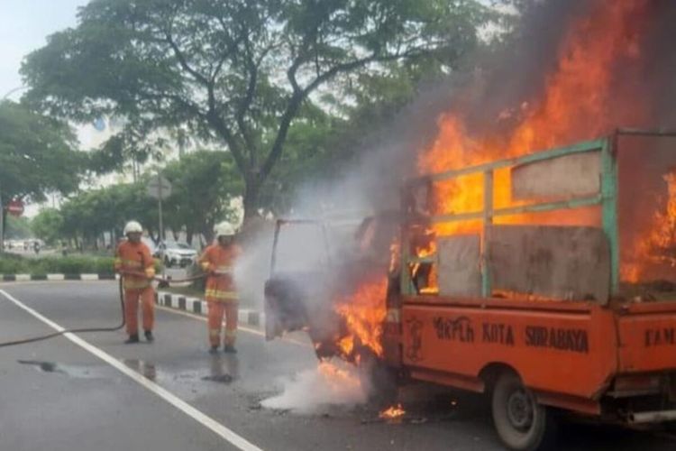 Petugas PMK Saat Memadamkan Mobil Pikap Milik DLH Surabaya yang Terbakar di Merr Kalijudan, Selasa (15/2/2022).