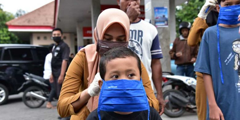 Petugas membagikan masker kain buatan UMKM.