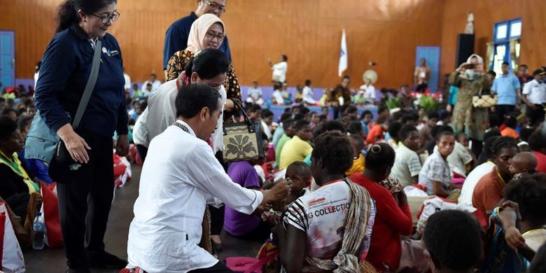 Presiden Joko Widodo (tengah) didampingi Ibu Negara Iriana Joko Widodo berbincang dengan ibu dengan balita saat penyerahan gizi makanan tambahan di Distrik Agats, Kabupaten Asmat, Papua, Kamis (12/4). Kunjungan kerja Presiden ke Asmat diantaranya untuk pemberian gizi makanan tambahan bagi ibu hamil dan anak-anak, memeriksa pembangunan tampungan air hujan serta pembangunan rumah bagi warga Asmat. 